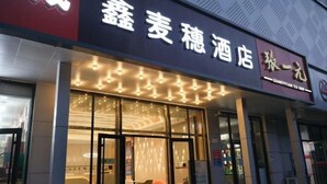 A hotel with a modern facade, large glass windows, and a well-lit entrance. - Xin Maisui Hotel (Shijingshan Chaoyang Hospital West Campus) (Beijing)