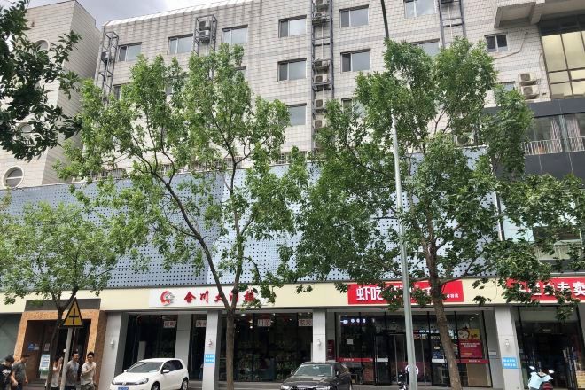 Un edificio con varias fachadas, incluyendo un letrero rojo con texto blanco.