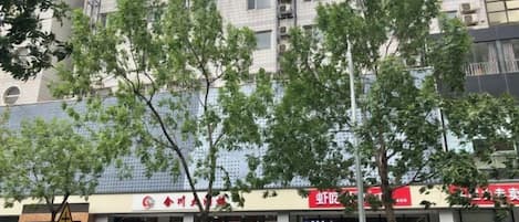 Un edificio con varias fachadas, incluyendo un letrero rojo con texto blanco.