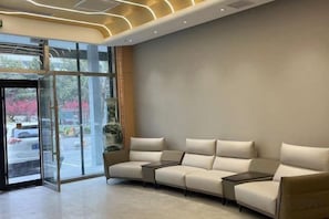 Un vestíbulo moderno con zona de estar, puertas de vidrio y vistas al exterior.