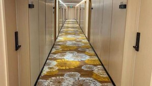 A long hallway with a floral carpet and doors on both sides. - Xin Maisui Hotel (Shijingshan Chaoyang Hospital West Campus) (Beijing)