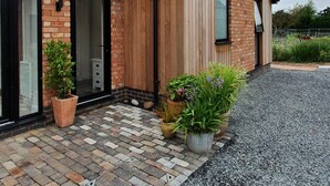 A modern house with a brick facade, large windows, and a gravel driveway. - The Flower Room - sleeps 2 guests  in 1 bedroom (Droitwich)