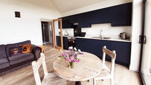 A modern kitchen with dark cabinets, a white countertop, and a stainless steel sink. - The Flower Room - sleeps 2 guests  in 1 bedroom (Droitwich)