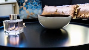 A clear glass bottle and a white bowl on a black tray. - The Glowing Ruby | By Radiant Apartments (Wien)