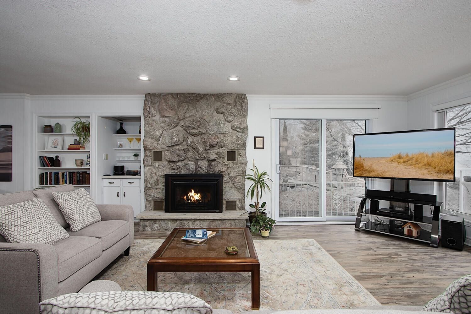 A living room with a fireplace, a sofa, a coffee table, and a TV.