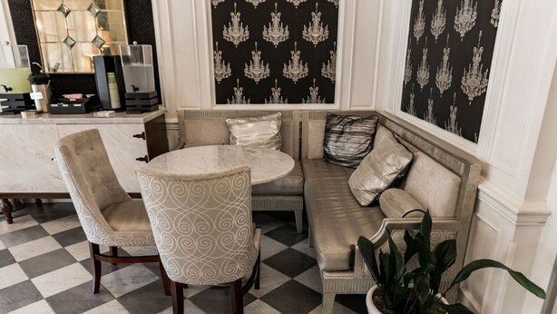 A room with a checkered floor, a round table, two chairs, a sofa, and a potted plant. - San Diego | City Retreat | Fitness + Sun Deck (San Diego)