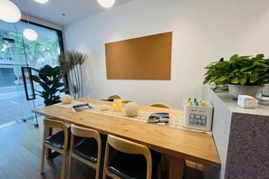 A wooden dining table with chairs, a placemat, and a sign with text. - Songhua Business Hotel (Shanghai)