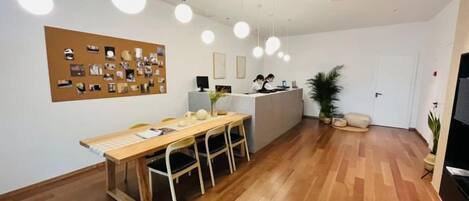A reception area with a wooden desk, chairs, a bulletin board, and a reception counter.