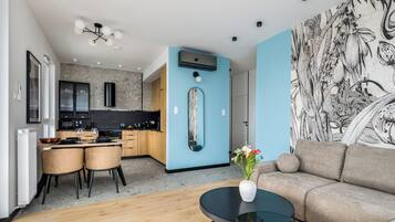 A modern living room with a sofa, a coffee table, and a dining area with chairs and a table.