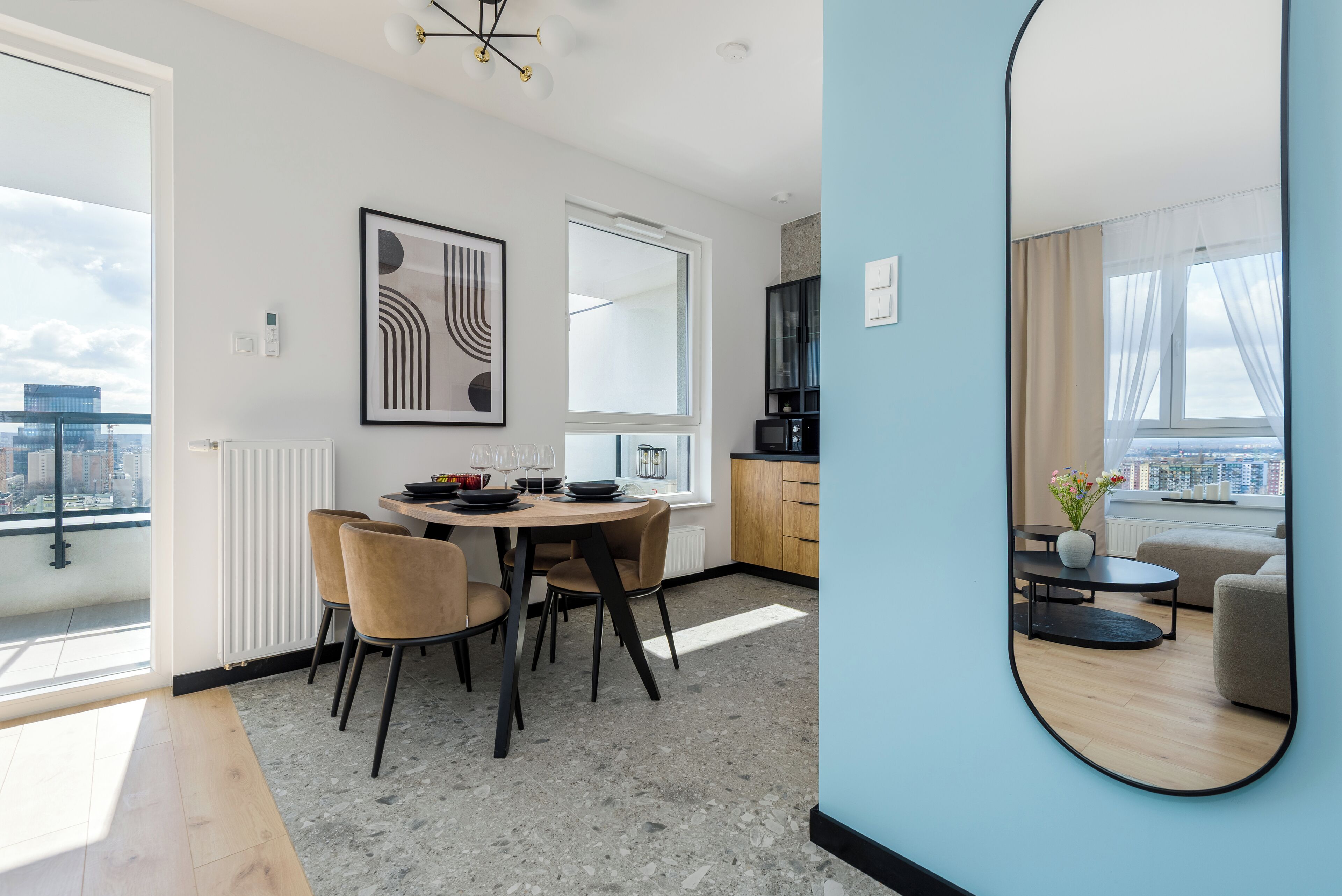 A modern apartment with a dining area, kitchen, and living space.