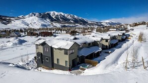 A residential area with modern houses, a hot tub, and a mountain backdrop. - 4 BR Cozy Upscale Mountain Retreat, Hot Tub, Mountain Views (Crested Butte)
