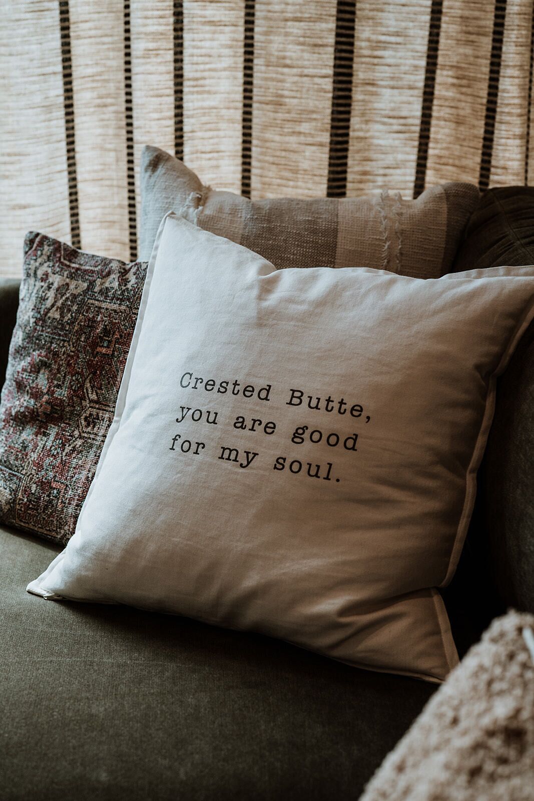 A cushion with a printed message on a sofa.