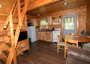 A wooden cabin interior with a kitchen, dining area, and a loft bedroom. - Log Cabin - Pool - Hot Tub - Sauna - 2301 (Bagley Township)