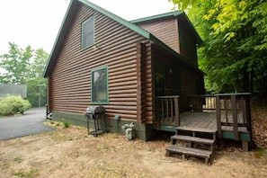 A log cabin with a porch and steps leading up to it.