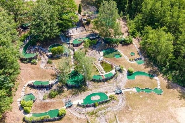 An aerial view of a golf course with multiple green areas and pathways.