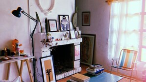 A cozy living room with a fireplace, a bookshelf, and a striped rug. - Casa Larica (Barra de Valizas)