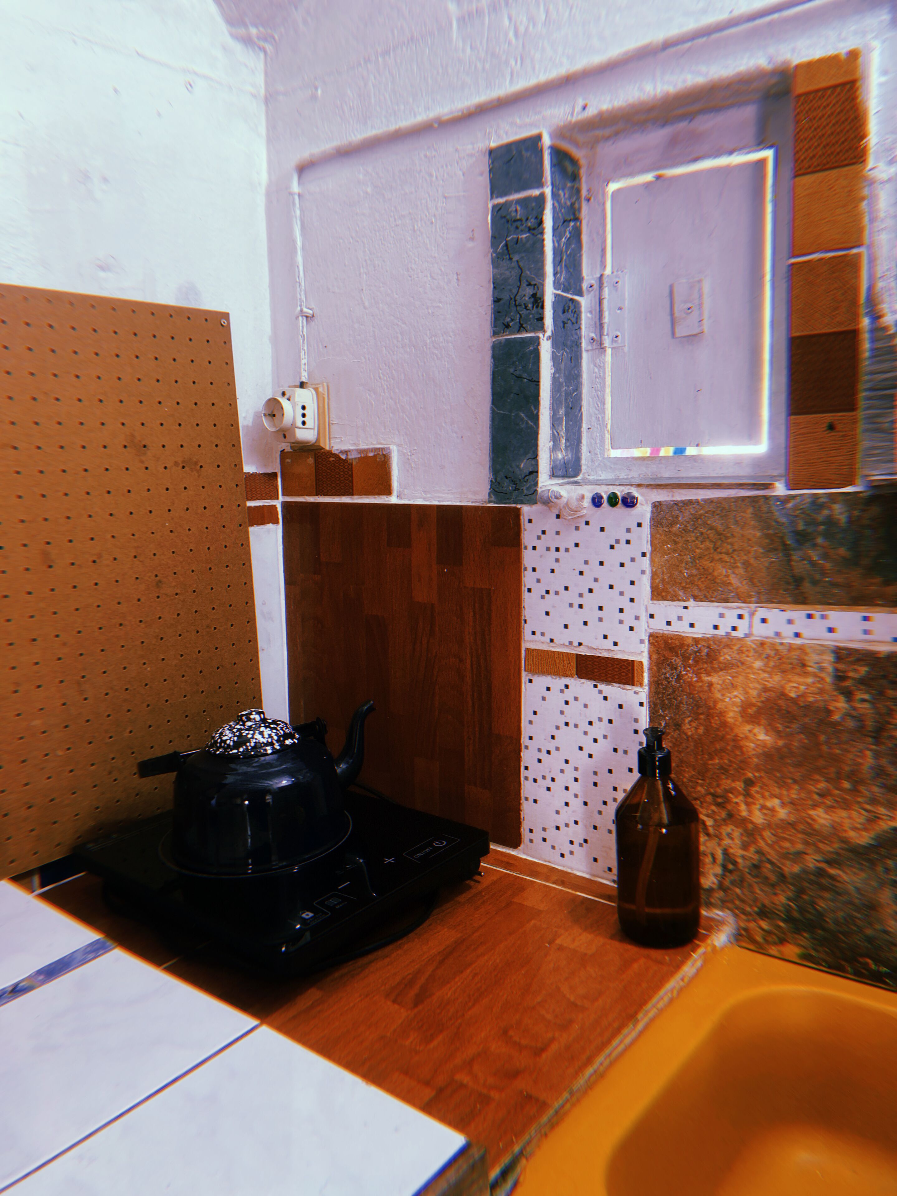 Una cocina con estufa, pileta y ventana.