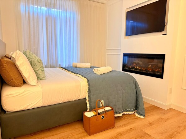 A bedroom with a bed, a fireplace, and a suitcase.