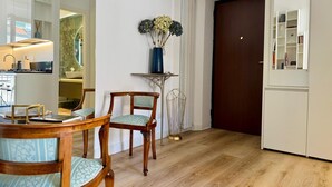 Una cocina moderna con comedor, sillas de madera y un jarrón con flores.