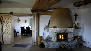 A stone fireplace with a fire, wooden beams, and a rustic decor. - Lipowe Wzgórze (Limanowa)