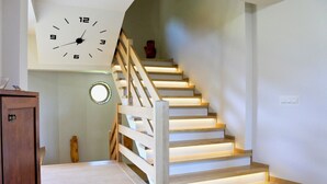 A staircase with wooden railings and a wall-mounted clock. - Lipowe Wzgórze (Limanowa)
