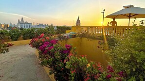 A rooftop garden with a view of a city skyline and a building with a dome. - by Calamari Homes - El Porvenir (Cartagena)