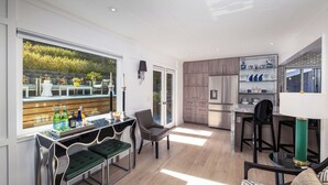 A modern kitchen with a built-in island, wooden cabinets, and a glass-fronted shelving unit. - Tranquil Home in Coto de Caza (Coto de Caza)