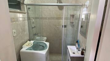 Chuveiro, toalhas de banho, sabonete, papel higiênico