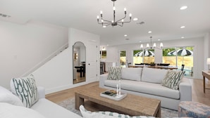 Ein modernes Wohnzimmer mit einem weißen Sofa, einem Holztisch und einer Chandeliebre.