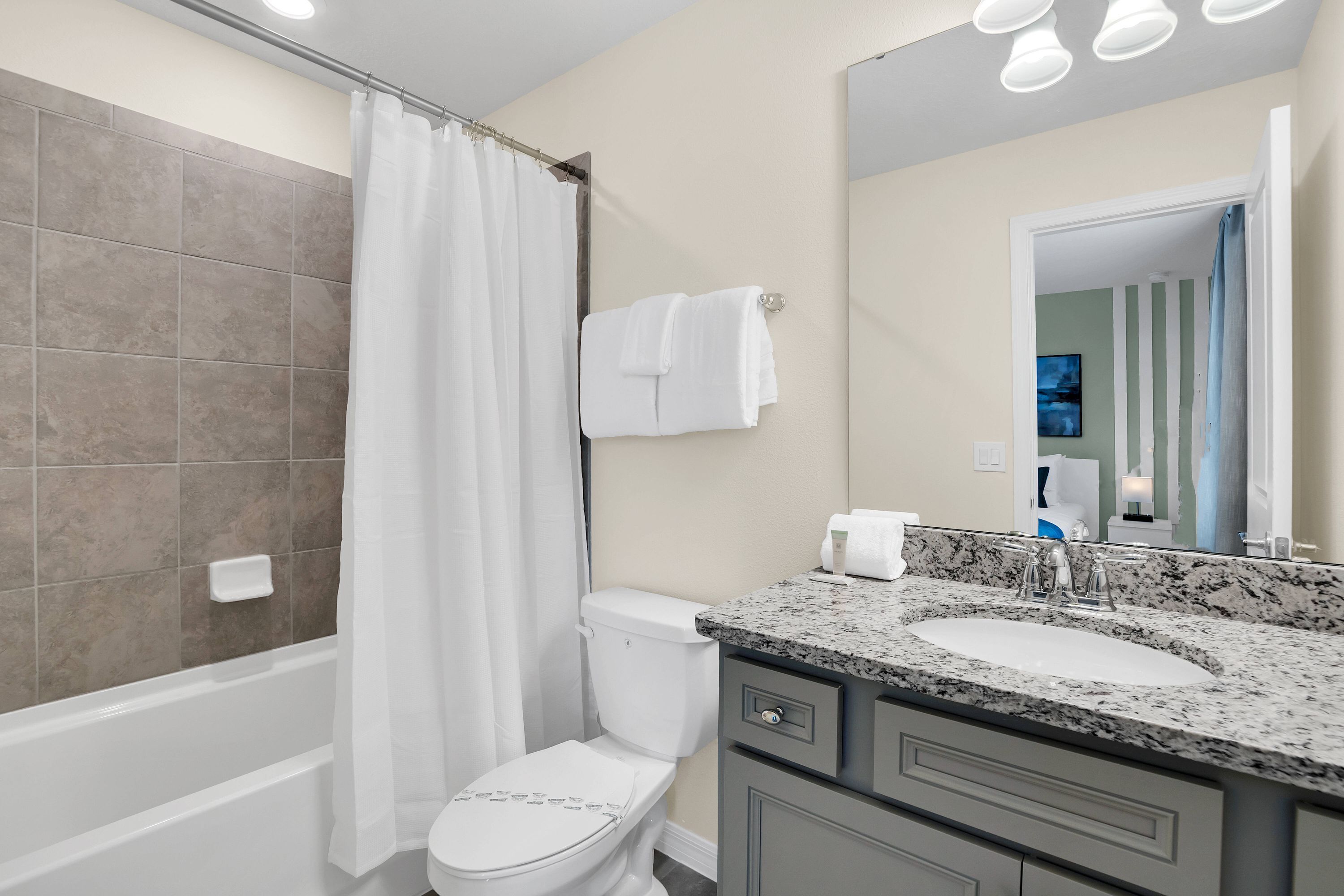 A modern bathroom with a bathtub, toilet, and sink.