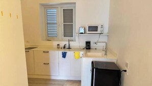 A compact kitchen with a microwave, coffee maker, and a small refrigerator. - Ocean Garden Studio 2 (St Johns)