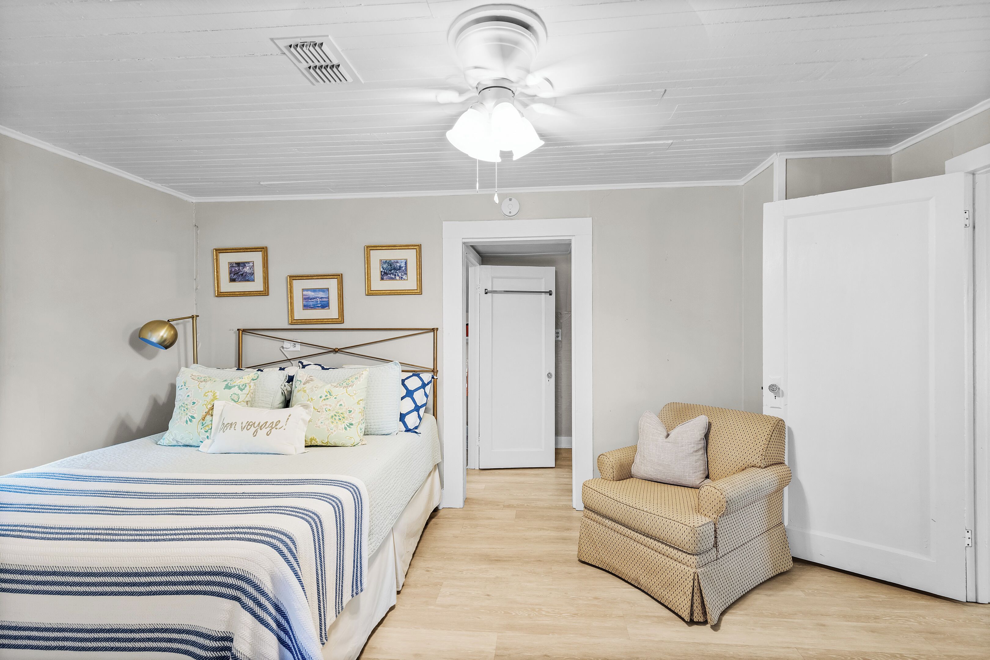 A bedroom with a bed, a chair, and a door.