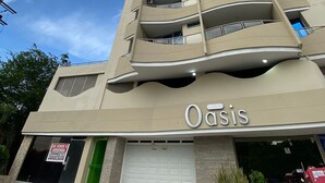 A multi-story hotel named 'Oasis' with a modern architectural design, featuring balconies and a garage entrance. - U-GO Edificio Oasis (Santa Marta)