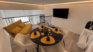 A dining area with a round table, chairs, and a sofa.