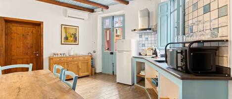 Frigorífic, microones, cafetera i tetera i una taula de menjador