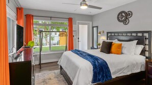 A bedroom with a bed, a desk, a chair, a window with curtains, a ceiling fan, and a view of the outdoors. - Pet-Friendly Gem | Fenced Yard | 10 Min Beach (Fort Lauderdale)