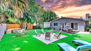 A backyard with a patio area, outdoor furniture, and a small shed.