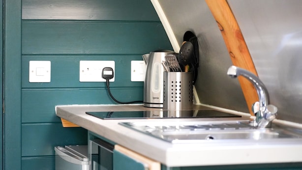 A kitchenette with a sink, a coffee maker, and a toaster. There are electrical outlets and a trash bin. - Deluxe Cosy Cabin in the Scottish Highlands (Tomintoul)