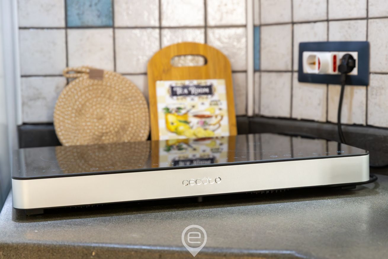 A kitchen with a countertop, a woven bag, a wooden cutting board, and a power outlet.