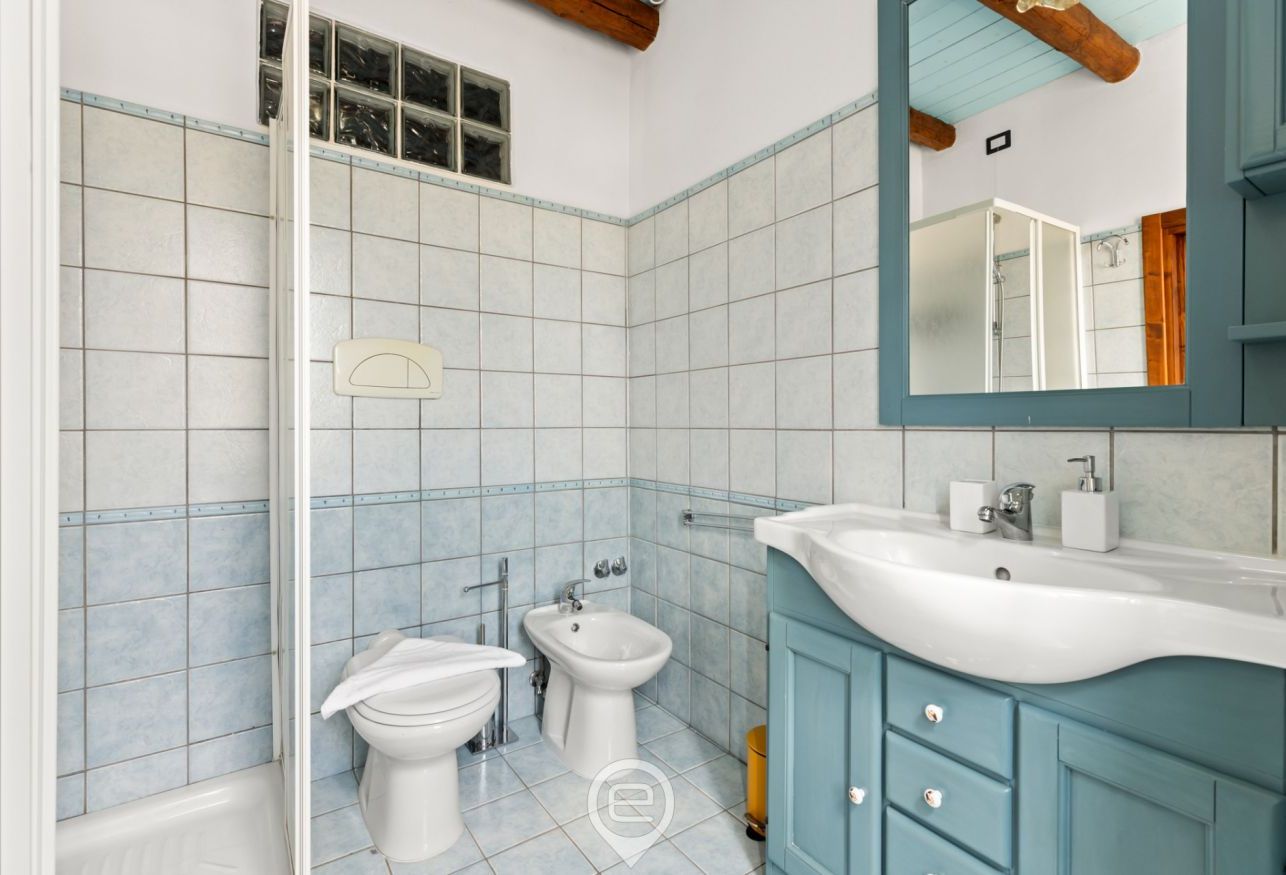 A bathroom with a bathtub, two sinks, a bidet, and a mirror.