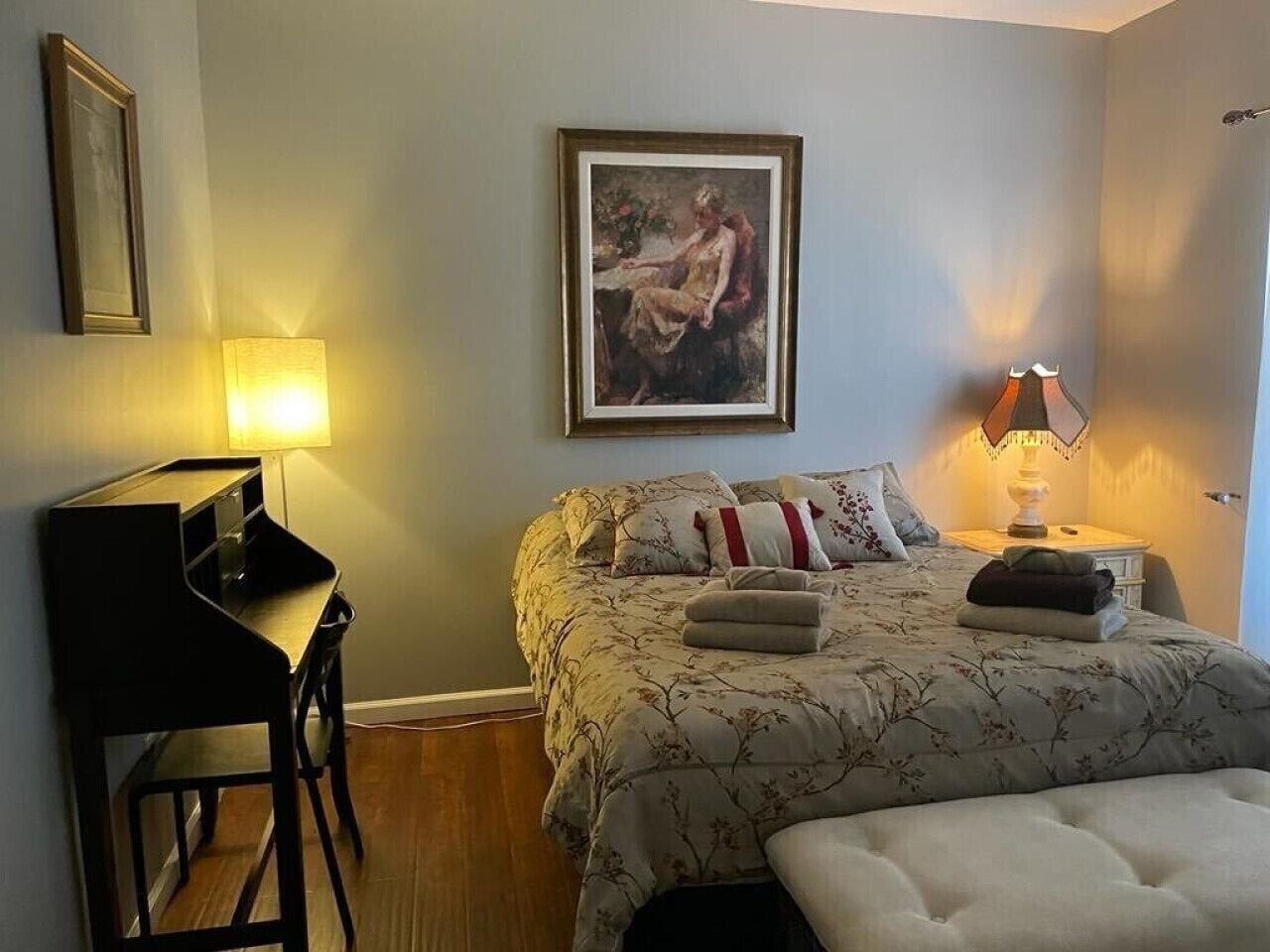 A bedroom with a bed, a desk, and a chair.