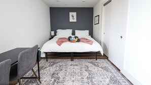 A bedroom with a bed, a desk, and a chair.