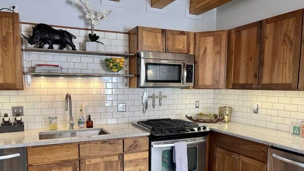 A kitchen with wooden cabinets, a stainless steel microwave, a stove, and a sink. - Charming 1-bedroom apartment with WiFi, AC in wonderful Denver (Denver)