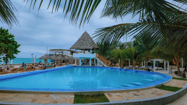 Una piscina al aire libre, sillones reclinables de piscina