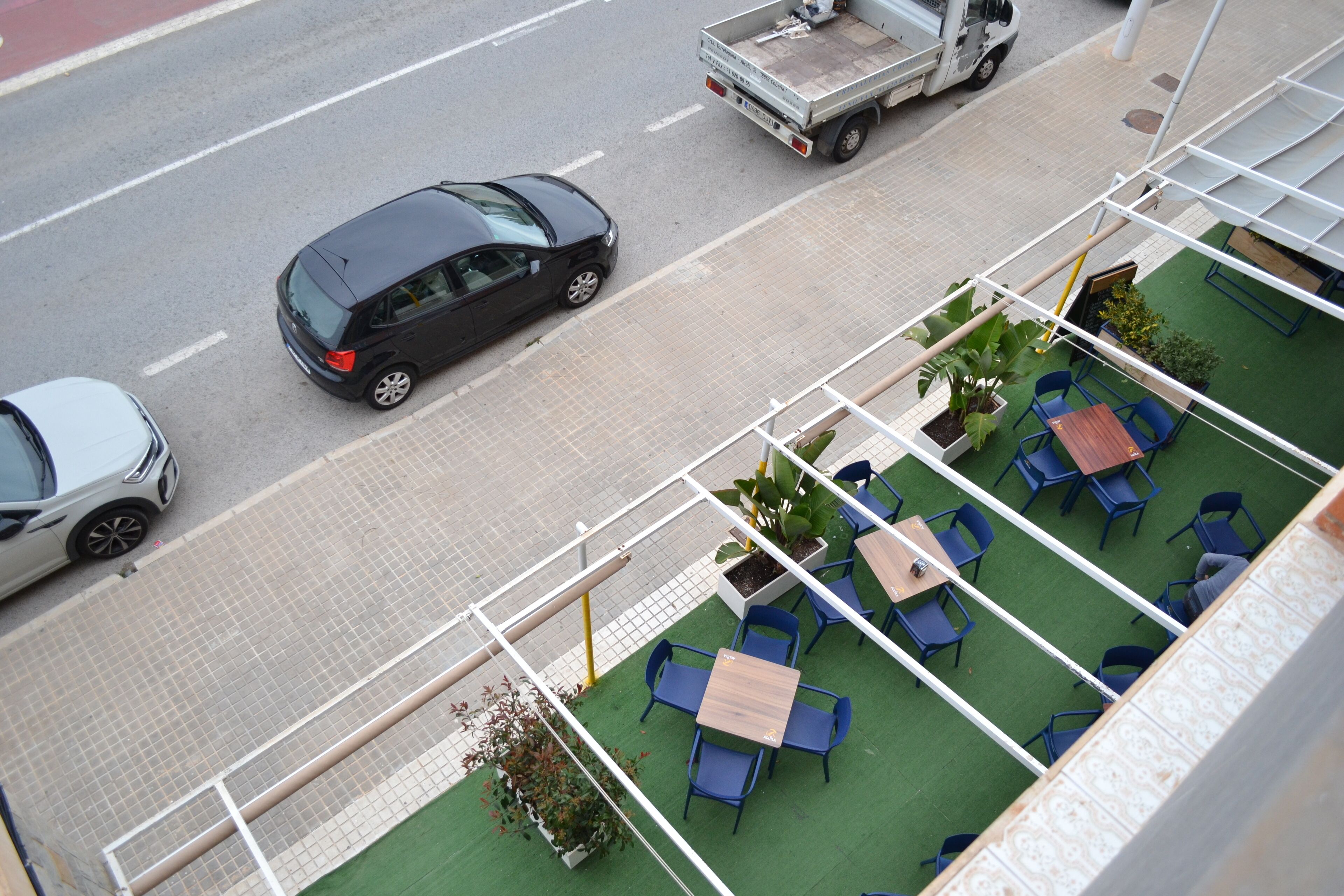 Terraza en la azotea con mobiliario exterior y vista a la calle.