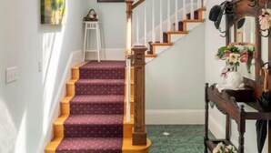 Un escalier avec des rampes en bois et une moquette à motifs.