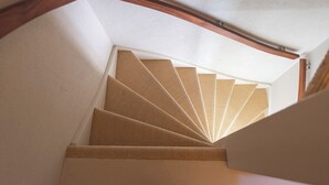 Eine Wendeltreppe mit Holzbalkon und strukturierter Wand.