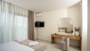 Une chambre d’hôtel moderne équipée d’un grand lit, d’un bureau, d’une chaise, d’un téléviseur à écran plat et d’un grand miroir.
