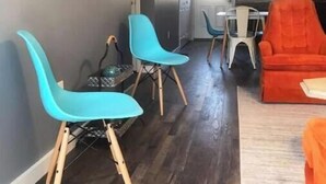 Un soggiorno moderno con zona pranzo, cucina e TV a parete.