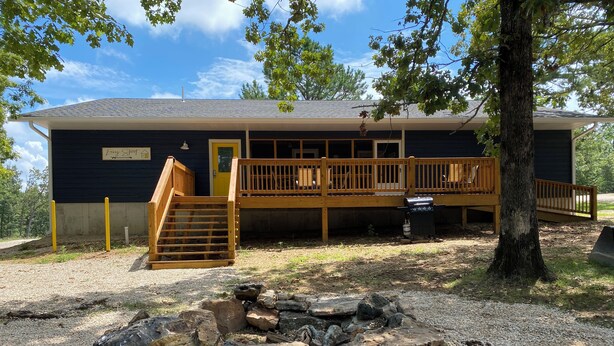 A cabin with a deck, a staircase, and a fire pit. - Easy Street Apartment (Van Buren)